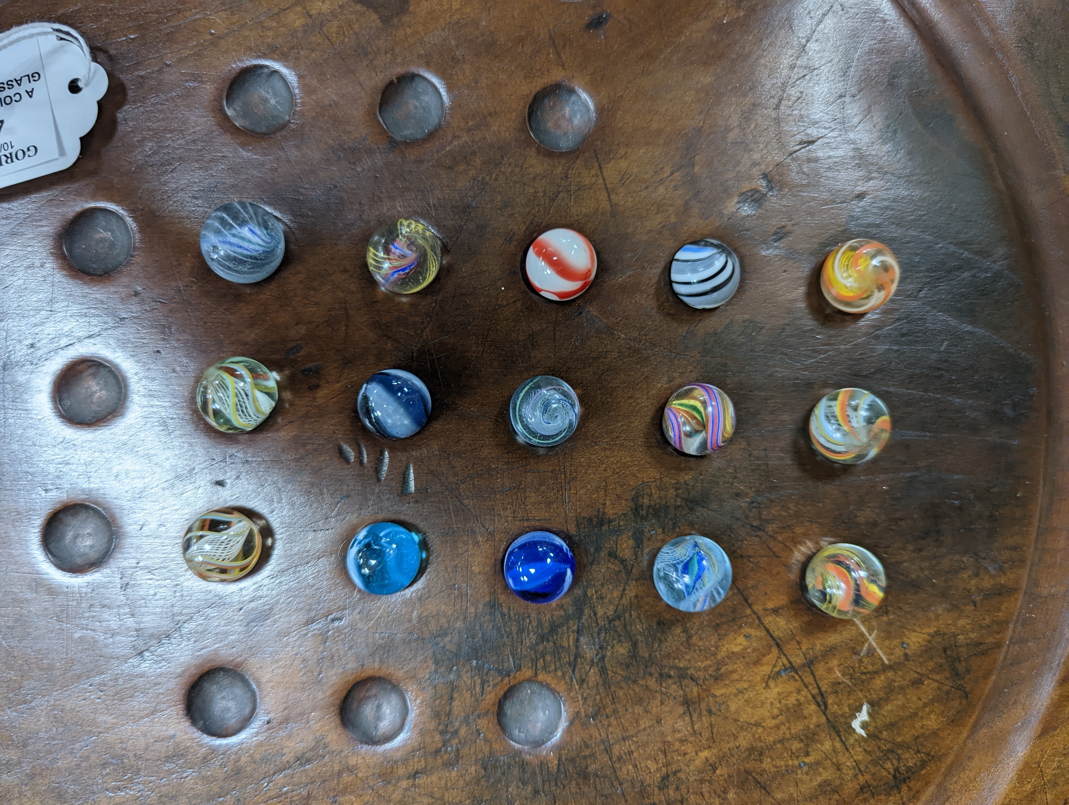 A collection of glass marbles and a mahogany solitaire board 45cm